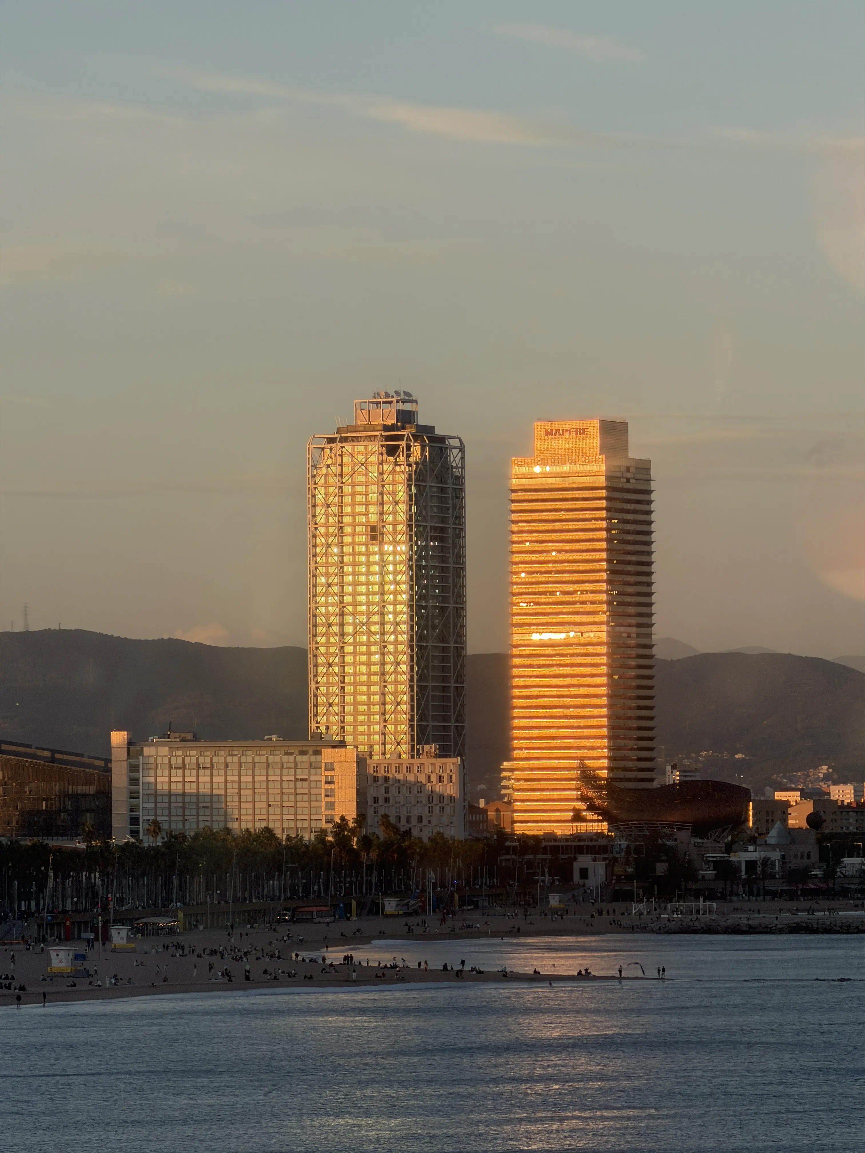 Barcelona golden hour, Torre Mapfre and Hotel Arts glowing in sunset light from Norrsken's rooftop