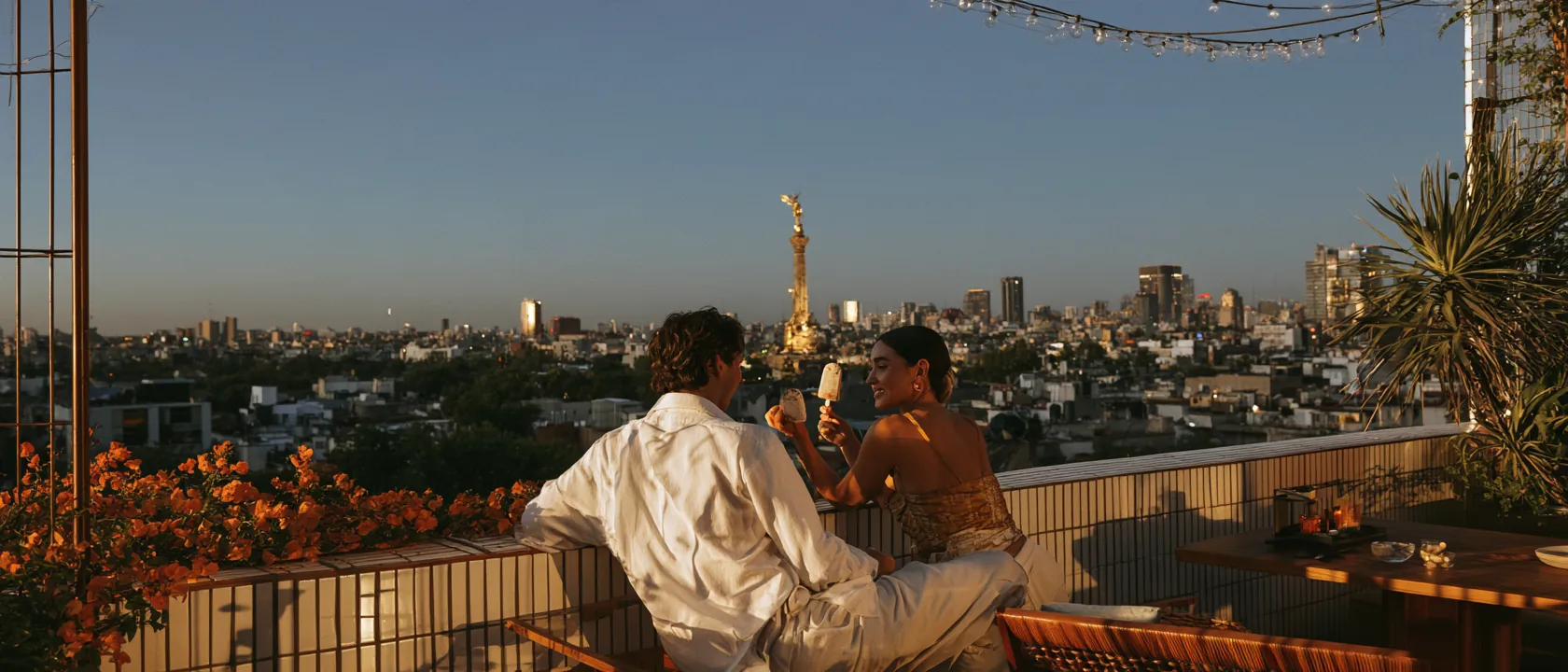 Two friends on a rooftop terrace in Mexico City at dusk